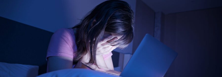 Addressing Bullying and Cyberbullying: woman suffer internet cyber bullying and feel depressed with laptop at home
