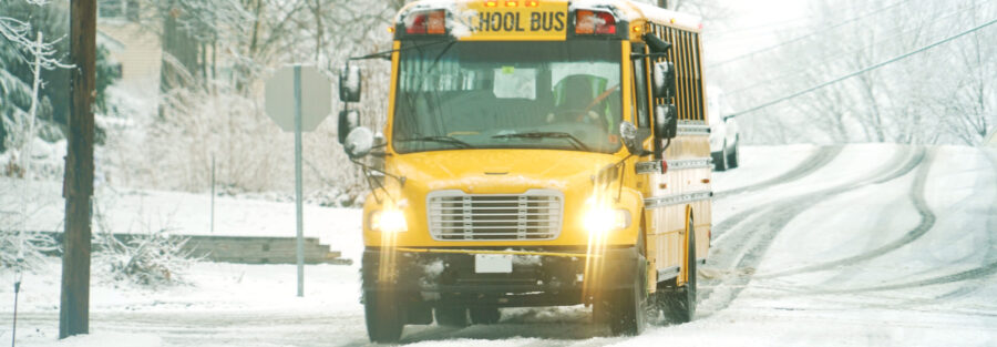 School bus driving in the winter weather snow.