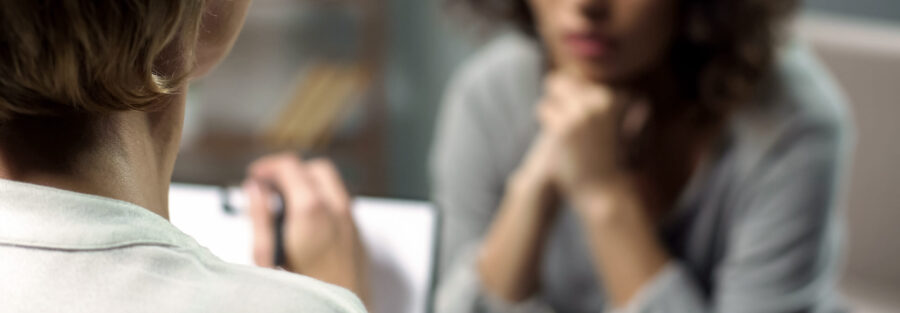 Young depressed woman talking to lady psychologist during session, mental health