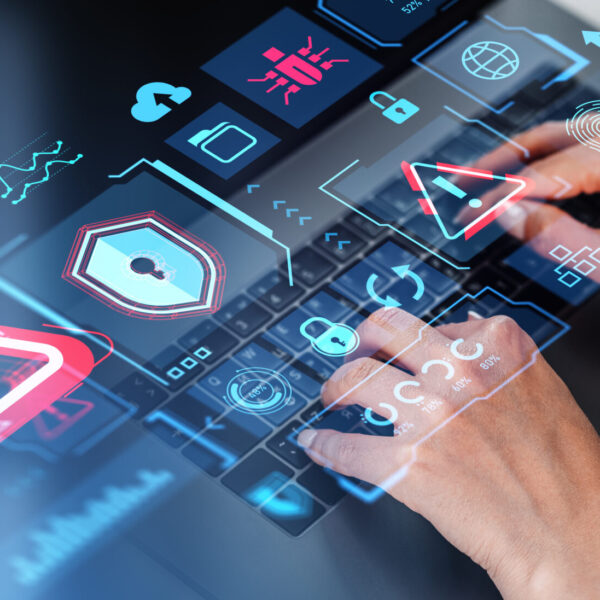 Hands of businesswoman using laptop at office table with double exposure of immersive cybersecurity interface. Concept of data protection